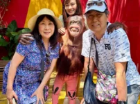 タイのサファリワールドでオランウータンと写真撮影を楽しむ60代夫婦と娘