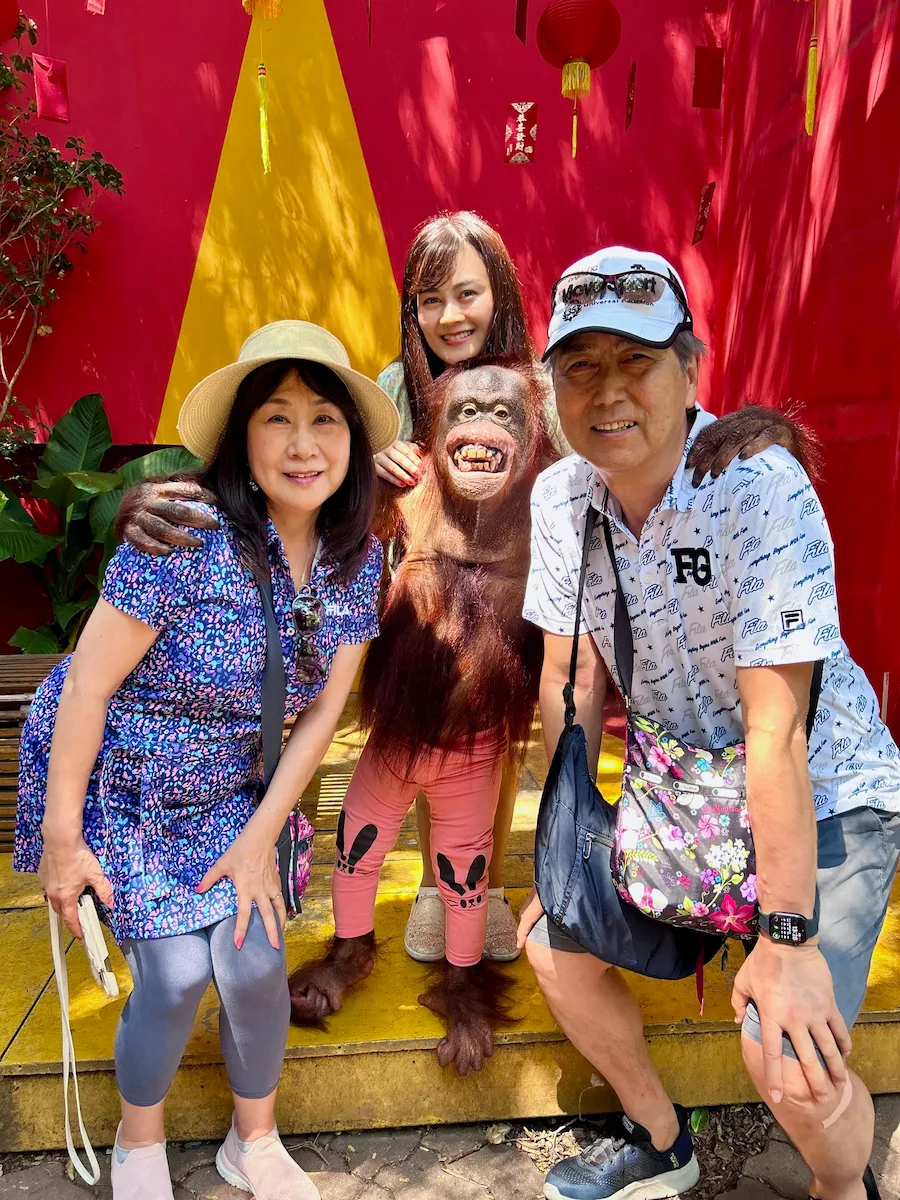 タイのサファリワールドでオランウータンと写真撮影を楽しむ60代夫婦と娘