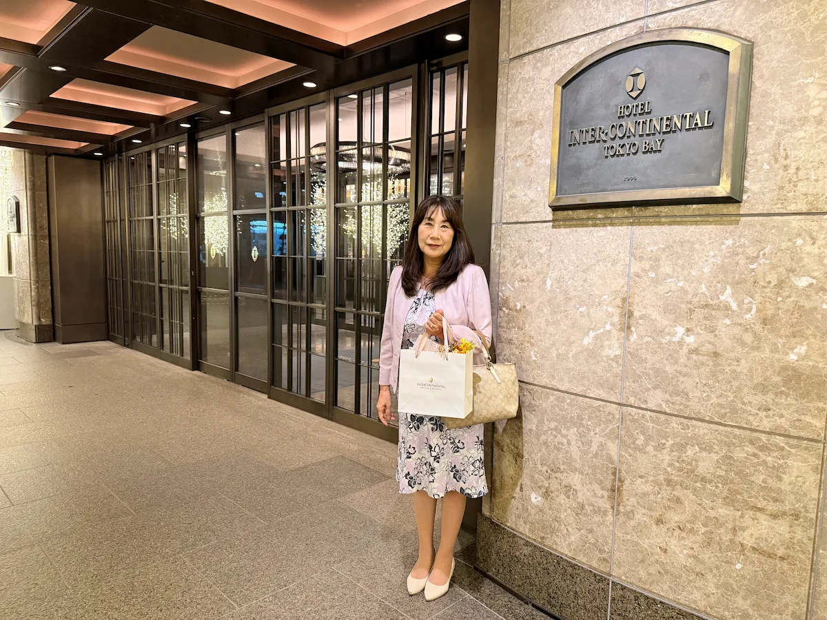 ホテル インターコンチネンタル 東京ベイ 玄関前でお花とドリップバッグを持つままリン編集長